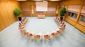 Vermietung Seminarräume Konferenzraum mit Stühlen im Halbkreis vor einem Tisch und einer Leinwand