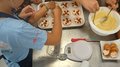 Backspaß und Kreativität – KidsAcademy backt in Kaltern Kinder dekorieren Muffins mit Beeren und Backteig in einer Küche