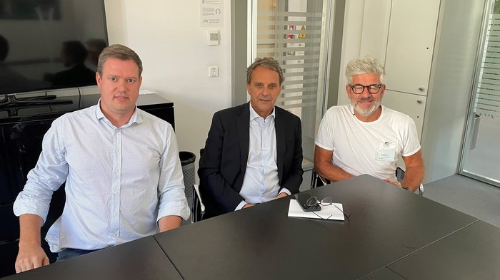 Alperia und lvh weiter auf Kooperationskurs Drei Männer sitzen an einem Tisch in einem Büro