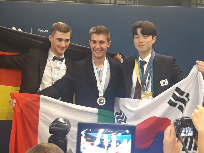 WorldSkills 2022 Special Edition: Zimmerer Marcel Bolego holt Silbermedaille Drei Medaillengewinner mit den Flaggen von Deutschland, Italien und Südkorea