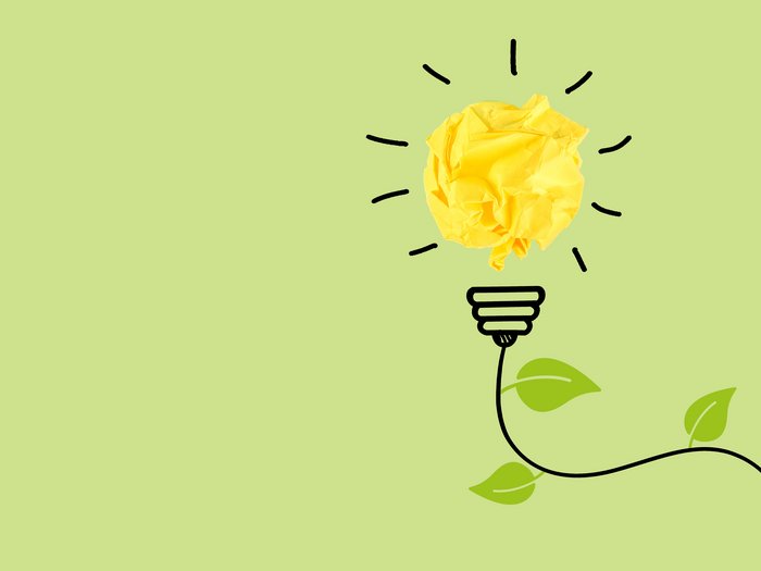 © Plattform Land Glühbirne aus zerknülltem gelbem Papier mit grünen Blättern auf hellgrünem Hintergrund