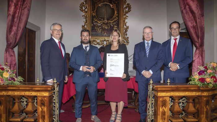 Südtiroler Wirtschaftspreis 2023: 6 Handwerksbetriebe des lvh ausgezeichnet Fünf Personen in formeller Kleidung posieren bei einer Urkundenverleihung in einem prunkvollen Raum