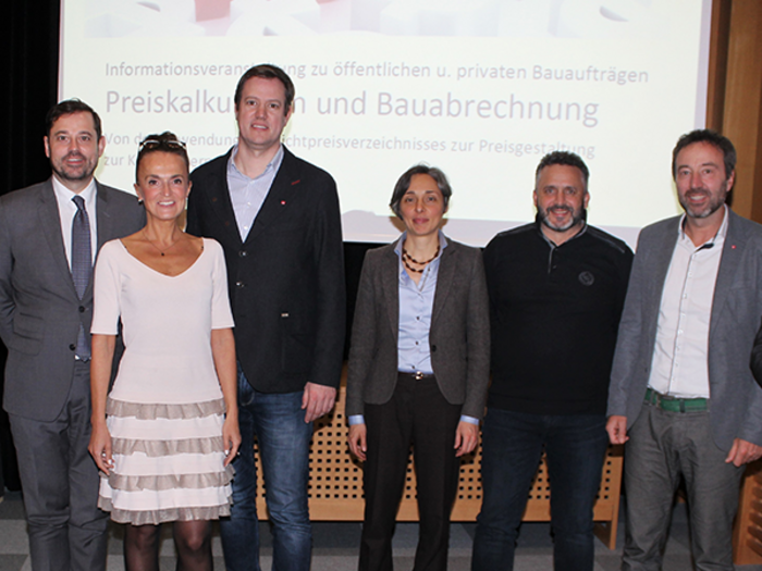 Auf dem richtigen Weg zu den öffentlichen Aufträgen Gruppenfoto von acht Personen vor Präsentationsbildschirm bei einem Bau-Event