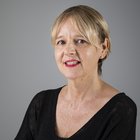 Orietta Quagliati Ritratto di donna con capelli corti biondi e rossetto rosso su sfondo grigio