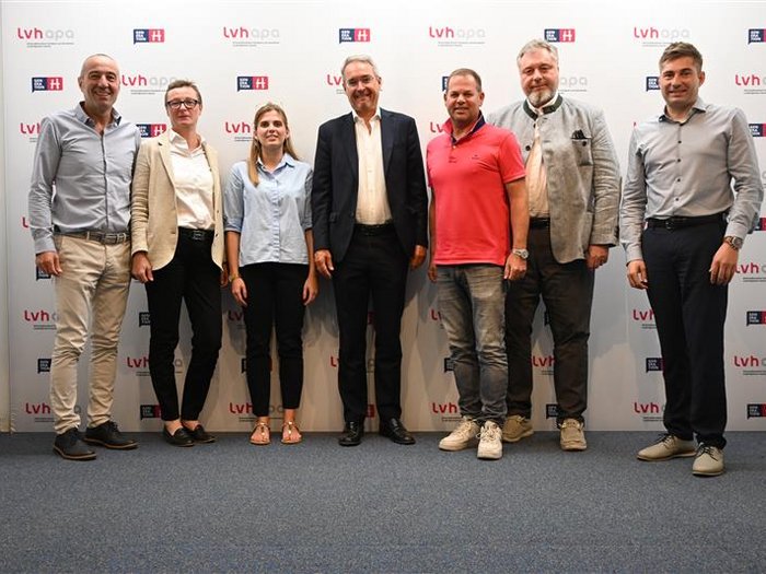 Dieter Steger im Haus des Handwerks Gruppe von sieben Personen steht vor LVH Apa Hintergrund