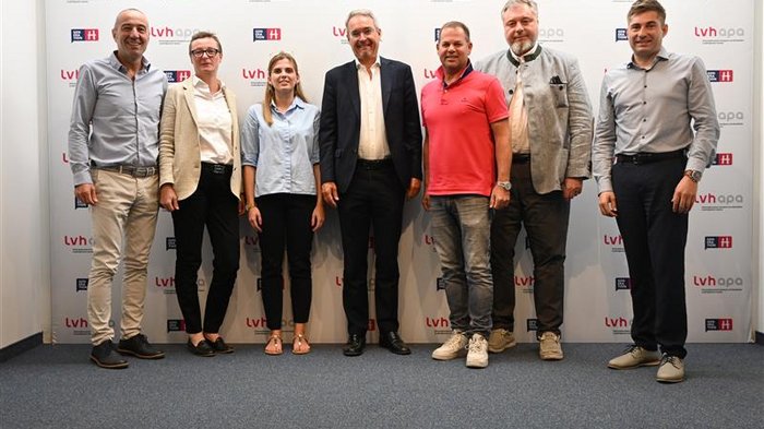 Dieter Steger im Haus des Handwerks Gruppe von sieben Personen steht vor LVH Apa Hintergrund