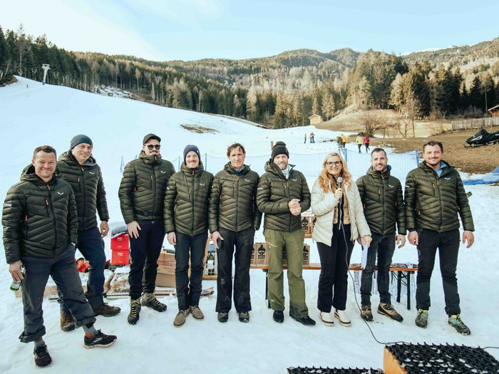 lvh Wintersportfest in Feldthurns Gruppe von zehn Personen in Winterjacken auf schneebedecktem Hang vor Wald und Bergen