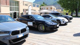 News Vier sportliche Autos vor einem modernen Gebäude bei sonnigem Bergwetter