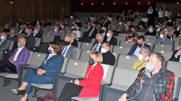 Landesversammlung des Südtiroler Handwerks Zuschauer mit Masken sitzen in einem gut besuchten Auditorium