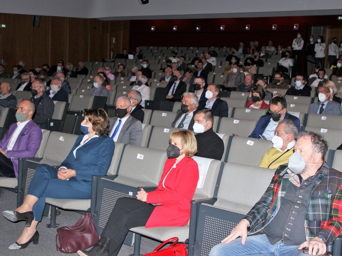 Landesversammlung des Südtiroler Handwerks Zuschauer mit Masken sitzen in einem gut besuchten Auditorium