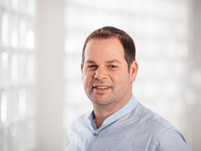 Verso un nuovo diritto alla riparazione Ritratto di uomo con camicia azzurra su sfondo chiaro sfocato