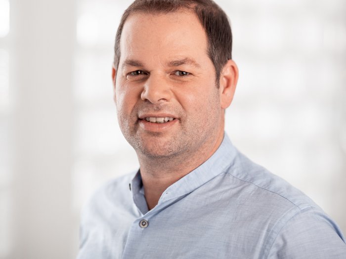 lvh begrüßt Investitionen des Landes in die Instandhaltung von Landesgebäuden Porträt eines Mannes mit blauem Hemd vor hellem unscharfem Hintergrund