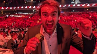 News Uomo festeggia con medaglia d'oro in una grande cerimonia davanti a un pubblico rosso