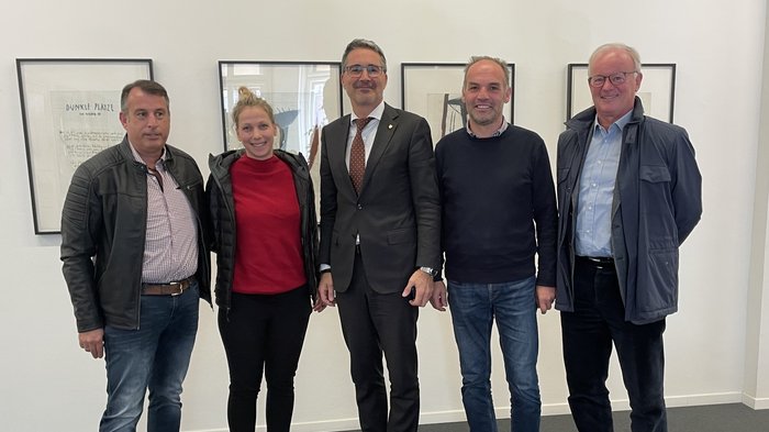 Landeshauptmann und Frächter suchen gemeinsam nach Lösungen für die Transportbranche Fünf Personen stehen nebeneinander vor einer weißen Wand mit gerahmten Bildern