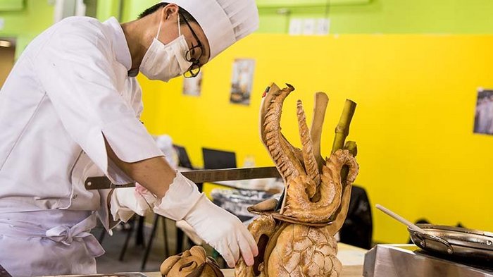 Einkaufen beim Metzger und Bäcker in eigenen Gemeinde weiterhin erlaubt Koch formt kunstvolle Brotskulptur in professioneller Küche