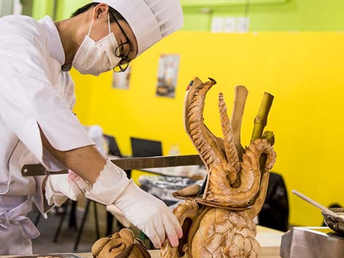 Einkaufen beim Metzger und Bäcker in eigenen Gemeinde weiterhin erlaubt Koch formt kunstvolle Brotskulptur in professioneller Küche