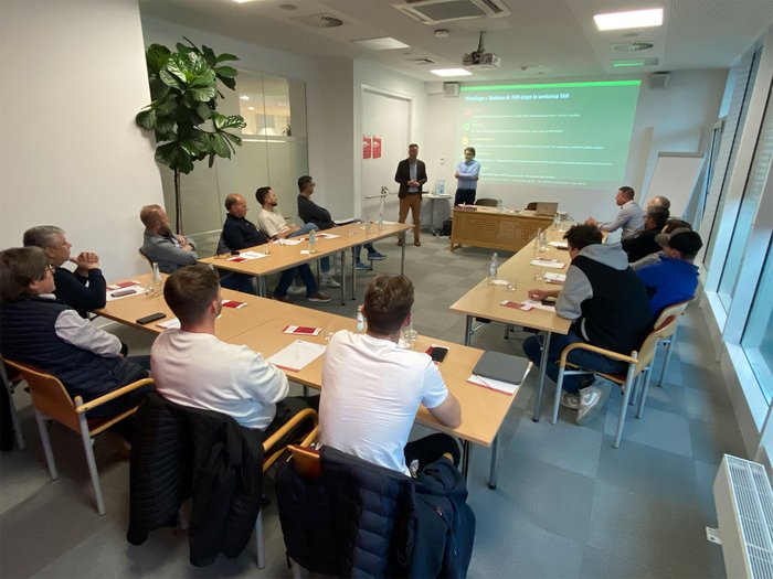 Die stille Arbeit hinter der Energiewende Menschen in einem Konferenzraum sehen einer Präsentation an der Wand zu