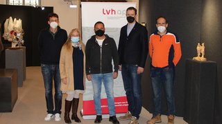 News Fünf Personen mit Masken stehen vor einem lvhap Banner in einer Galerie