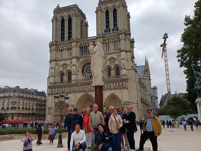 lvh-Seniorinnen und Senioren auf Frühlingsreise: Paris, mon amour! Gruppe von Touristen vor der Kathedrale Notre-Dame in Paris bei bewölktem Himmel