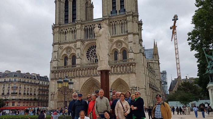 lvh-Seniorinnen und Senioren auf Frühlingsreise: Paris, mon amour! Gruppe von Touristen vor der Kathedrale Notre-Dame in Paris bei bewölktem Himmel