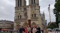 lvh-Seniorinnen und Senioren auf Frühlingsreise: Paris, mon amour! Gruppe von Touristen vor der Kathedrale Notre-Dame in Paris bei bewölktem Himmel