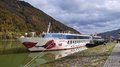 Auf Reisen: Althandwerker auf Flusskreuzfahrt Flusskreuzfahrtschiff A-ROSA Donna an einem bewaldeten Uferkai bei bewölktem Himmel