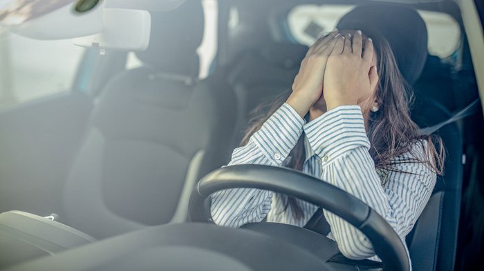 Neue Straßenverkehrsordnung: lvh legt Veto ein Fahrerin bedeckt verzweifelt das Gesicht im Auto