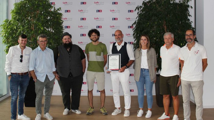 Jahresversammlung und neuer Obmann Gruppe von neun Personen, eine hält eine Urkunde, Hintergrund mit LVH APA-Logos