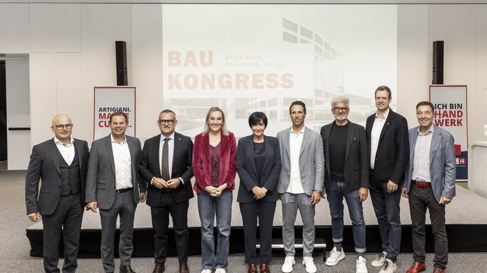 Congresso dell'edilizia 2025: costruire il futuro attraverso la cooperazione Foto di gruppo di dieci persone davanti a uno schermo con scritto Baukongress