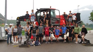 News Gruppe von Jugendlichen und Erwachsenen vor einem roten Arbeitsfahrzeug im Freien