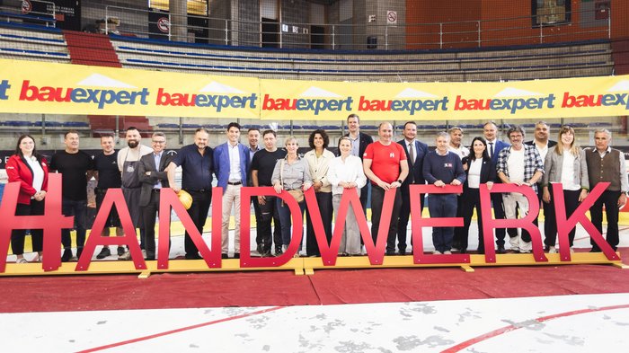 "Avventura artigianato" entusiasma a Merano: i giovani talenti vivono l’artigianato da vicino Gruppo di persone dietro grandi lettere che formano la parola Artigianato in un palazzetto