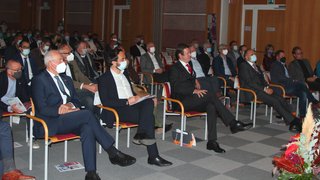 News Persone con mascherine sedute in una sala durante un evento