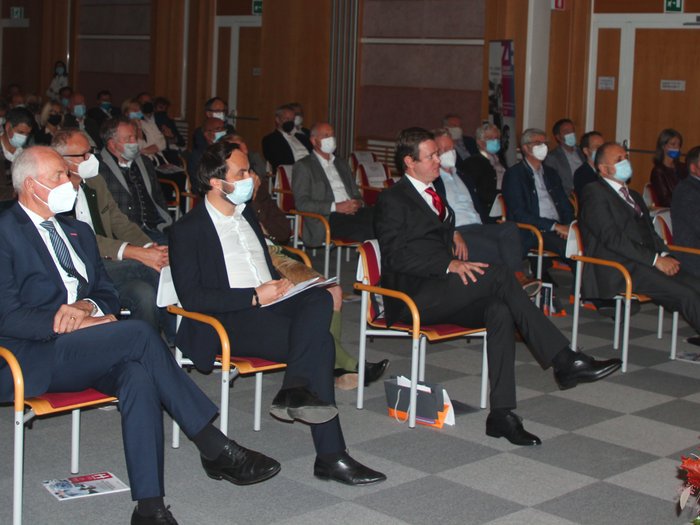 „Kinder, werdet Handwerker!“ Menschen mit Masken sitzen in einem Saal bei einer Veranstaltung