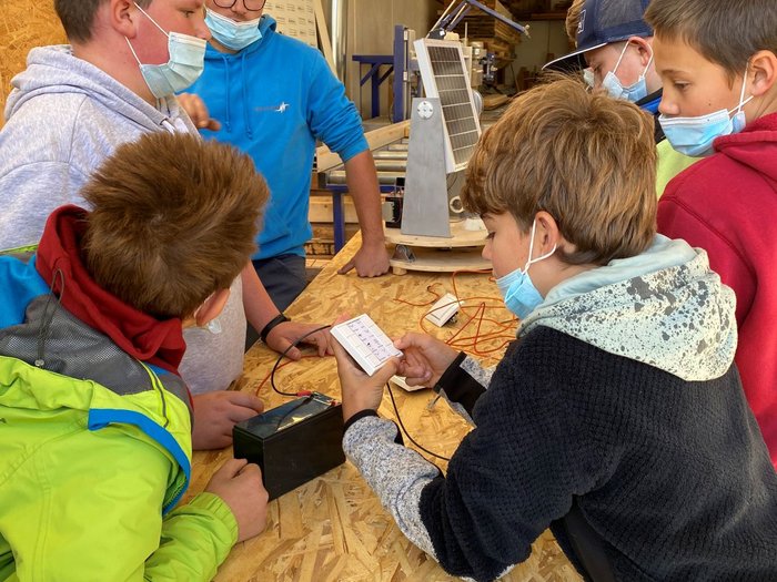 Praktische Berufe zum Greifen nahe Jugendliche experimentieren mit Solarzellen und elektrischen Bauteilen in Werkstatt