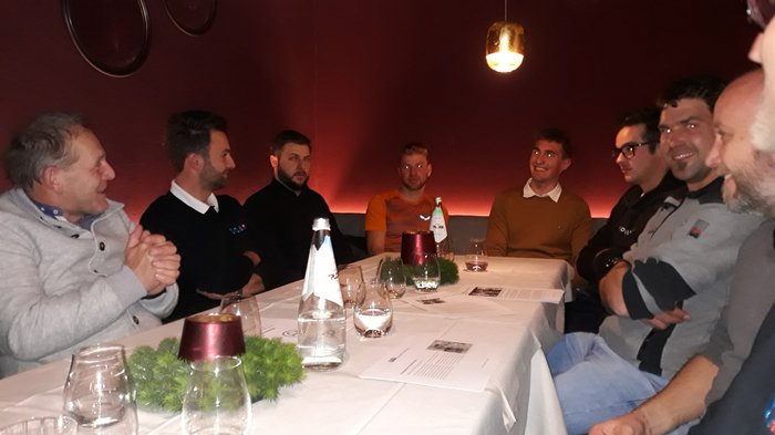 Dankesessen der Zimmerer Acht Männer sitzen an einem Tisch in einem Restaurant und unterhalten sich.