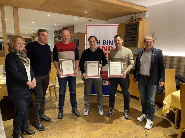 Handwerk: Brenner und Sterzing erneuern Ortsgremien Sieben Personen stehen, drei halten Urkunden für eine Ehrung in einem Raum