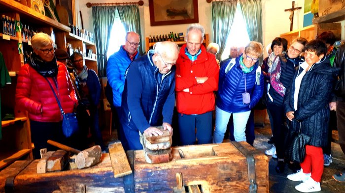 Unsere Althandwerker zu Besuch in der Stiermark Gruppe älterer Menschen beobachtet handwerkliche Demonstration mit Holz in Werkstatt