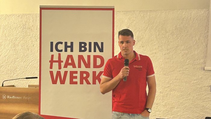 Eppan: Handwerk ist bereit, Verantwortung zu übernehmen Mann hält Mikrofon vor Banner ich bin Handwerk bei Veranstaltung