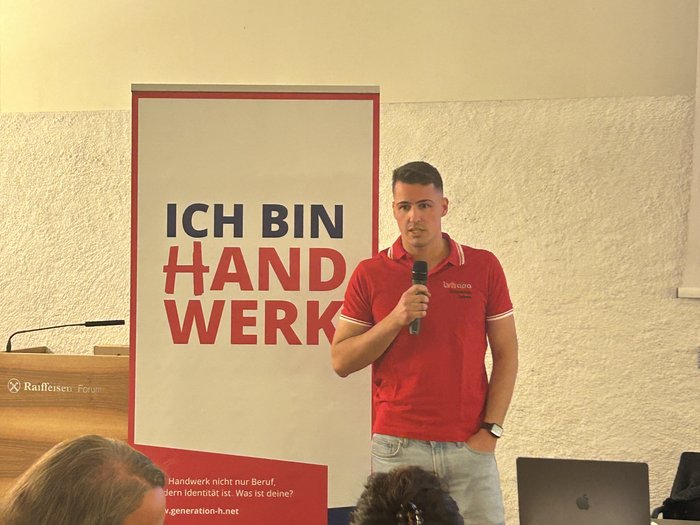 Eppan: Handwerk ist bereit, Verantwortung zu übernehmen Mann hält Mikrofon vor Banner ich bin Handwerk bei Veranstaltung