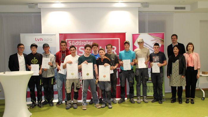 Die Zukunft des Handwerks Gruppe junger Männer mit Zertifikaten bei Preisverleihung