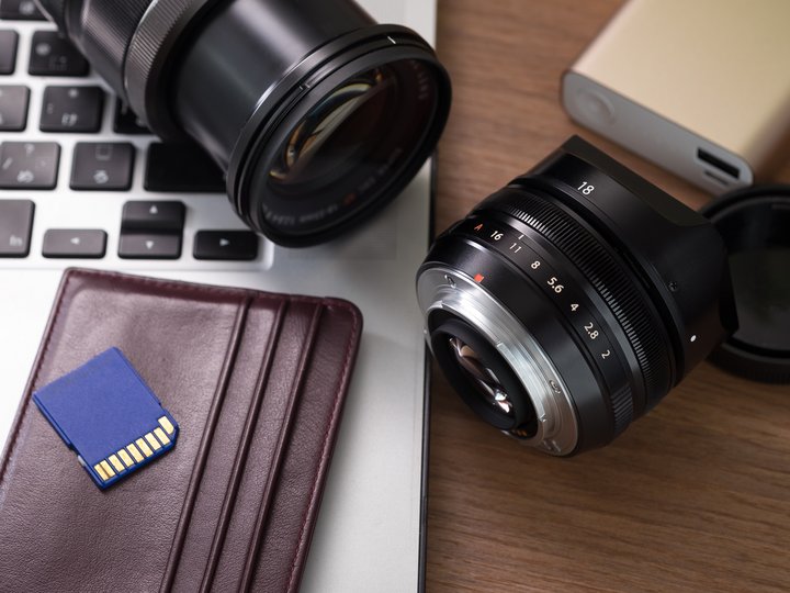 Fotografi e videomaker Obiettivi fotografici, scheda SD, laptop e portafoglio su tavolo in legno