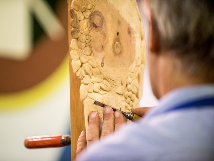 Intagliatori in legno Artigiano scolpisce motivi floreali su legno con scalpello