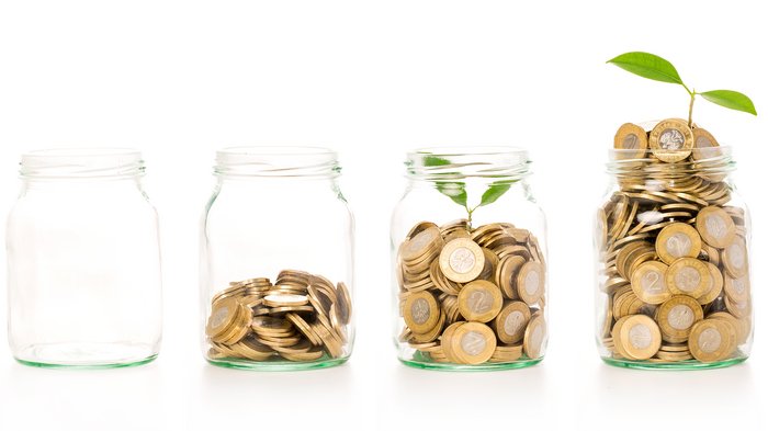 Ulteriori contributi per gli investimenti delle imprese Quattro barattoli con monete crescenti e pianta simbolo di crescita
