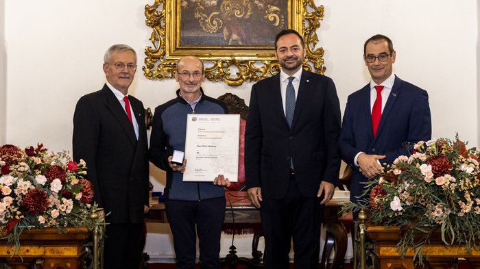 Südtiroler Wirtschaftspreis 2024 Vier Männer bei einer Auszeichnung, einer hält eine Urkunde und eine Medaille