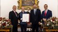 Südtiroler Wirtschaftspreis 2024 Vier Männer bei einer Auszeichnung, einer hält eine Urkunde und eine Medaille