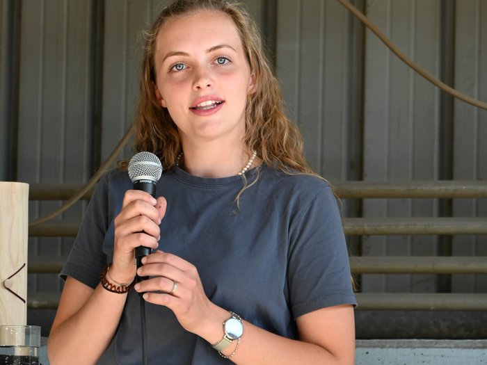 Junghandwerkerin des Jahres gekürt Frau hält Mikrofon und spricht vor grauem Hintergrund