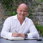 Unterpustertal/Gadertal Lächelnder Mann in weißem Hemd schreibt in Notizbuch im Freien