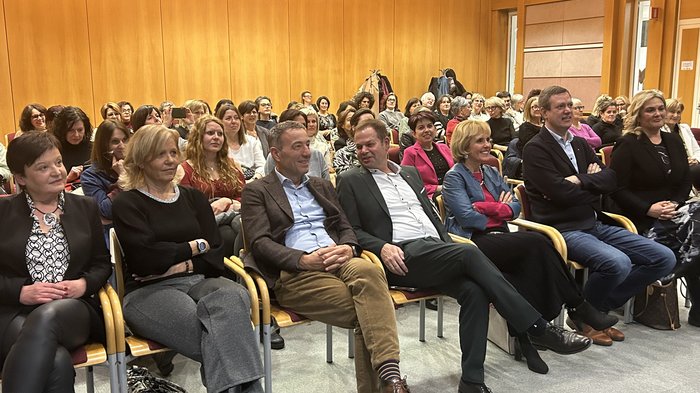 Neujahrsempfang der Frauen im Handwerk: „WIR gestalten Zukunft“ Volle Sitzung mit Männern und Frauen, die einem Vortrag in einem Raum mit Holzpaneelen zuhören