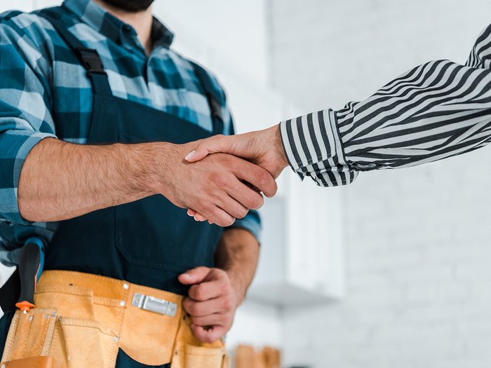 Mitglieder geben starkes Signal: lvh überzeugt mit Leistung und Haltung Handschlag zwischen Handwerker mit Werkzeuggürtel und Person im gestreiften Hemd