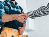 Home Stretta di mano tra artigiano con cintura degli attrezzi e persona con camicia a righe